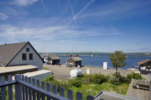 Blick auf einen Hafen mit Haus und Wasser in der Unterkunft Haus ButjeButje Haus - Terrasse, Sauna, Yachthafen in Gager