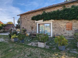a brick house with a picnic table in the yard at Chambre d'hôtes avec jardin, activités familiales et parking sécurisé au cœur du Berry - FR-1-591-448 in Vijon