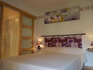 a bedroom with a white bed and a painting on the wall at Chambre d'hôtes avec jardin, activités familiales et parking sécurisé au cœur du Berry - FR-1-591-448 in Vijon +6 photos