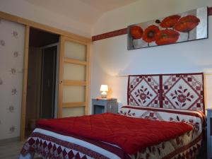 a bedroom with a bed with a red bedspread at Charmante Chambre Coquelicot : calme, activités variées, accès indépendant, parking sécurisé. - FR-1-591-450 in Vijon