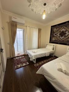 a hotel room with two beds and a window at Boulevard in Bukhara