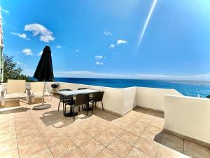 eine Terrasse mit einem Tisch, Stühlen und Meerblick in der Unterkunft Residence Canella in Sari Solenzara
