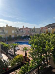 a view of a pool with palm trees and houses at Arenita Apartment in Palm-Mar
