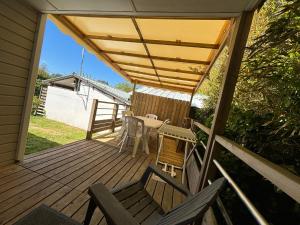 a wooden deck with a table and chairs on it at Camping Le Repos in Saint-Palais-sur-Mer