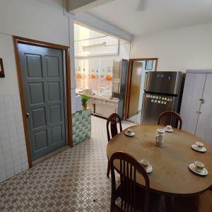 una cucina con tavolo e sedie e una cucina con frigorifero di Cheras Landed Homestay 4BR - 10Pax - MRT Suntex a Cheras