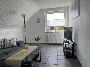 a living room with a couch and a table at NEU! Ferienwohnung Up de Warf in Dornum