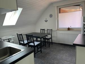 a kitchen with a table and chairs and a window at NEU! Ferienwohnung Up de Warf in Dornum +7 photos
