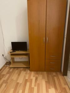 a desk with a computer next to a wooden cabinet at Sobe Braica in Drniš