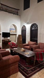 un soggiorno con divani, tavolo e pianoforte di Al Koot Heritage Hotel a Al Hofuf