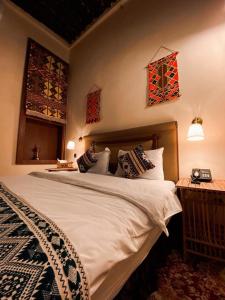 sypialnia z dużym białym łóżkiem z poduszkami w obiekcie Al Koot Heritage Hotel w mieście Al-Hufuf