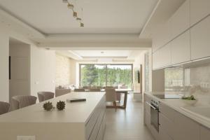 cocina con armarios blancos y comedor en Reflection Villa, Heated Pool & Absolute Seclusion, By ThinkVilla, en La Canea