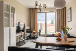 a living room with a table and chairs at City Center Apartments Grano Residence in Gdańsk