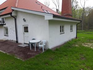 a small white house with a table and two chairs at - Schönes kleines Apartment zum Schlafen - in Moholm