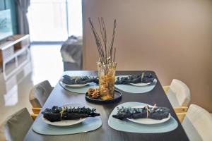 a table with four plates of food on it at Continew Residence KL CoBNB in Kuala Lumpur