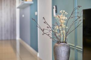 a silver vase with flowers in a hallway at Continew Residence KL CoBNB in Kuala Lumpur