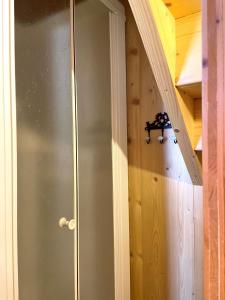 Una puerta de vidrio en una habitación con una pared de madera. en Studio Tiny en duplex - face télécabines, en Ax-les-Thermes