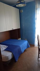 a bedroom with a bed with a blue wall at B&B Serena in Casapulla