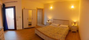 イグレージアスにあるAlba Sarda Residenceのベッドルーム1室(ベッド1台、壁に照明2つ付)