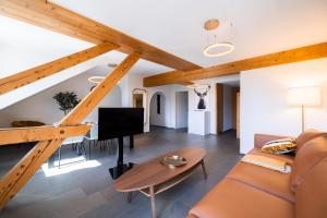 ein Wohnzimmer mit Holzbalken und einem Sofa in der Unterkunft EH Apartments Uranus in Flims