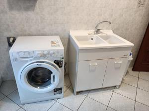 una lavatrice e un lavandino in bagno di B&B Mombracco a Envie