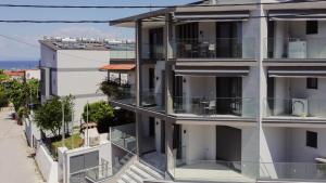 an apartment building with glass balconies and a street at ARA Luxury Suites in Polykhrono