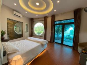 a bedroom with a large bed and a large window at Biển Đông COMPLEX in Lương Sơn