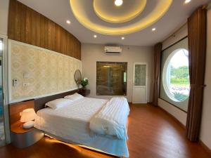 a bedroom with a large bed and a large window at Biển Đông COMPLEX in Lương Sơn