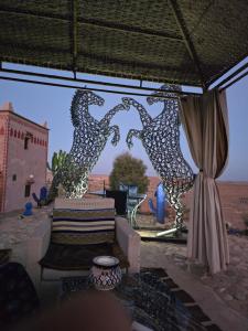 um quarto com uma cadeira e vista para o deserto em Riad Paradise of Silence em Aït Ben Haddou