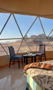 Zimmer mit 2 Stühlen und einem Tisch in einem Zelt in der Unterkunft Lukasa camp Wadi Rum in Wadi Rum