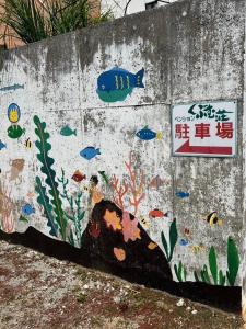 a wall with a painting of fish on it at くぶむ荘 in Shimoyatori