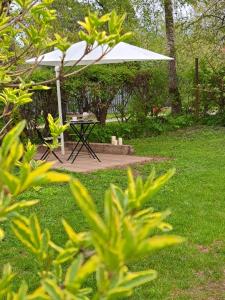 a picnic table with a white umbrella in a yard at Pērle in Ragaciems