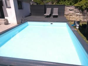 a large swimming pool with two chairs in a yard at A 2 pas d AZAY in Neuil