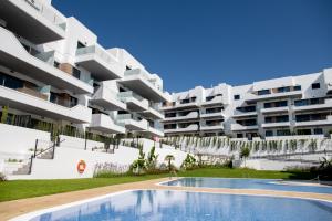 an apartment building with a swimming pool in front of it at The Aire Residencial by Mar Holidays in Orihuela