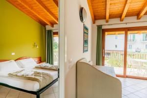 a bedroom with two beds and a balcony at Residence Molino - Holiday Apartments in Manerba del Garda