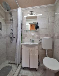 a bathroom with a sink and a toilet and a shower at Kućica na Drini "JAZ" in Višegrad