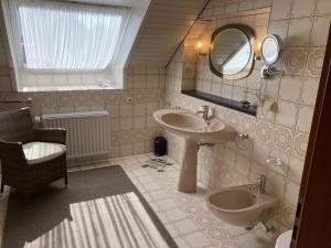 ein Badezimmer mit einem Waschbecken, einem Spiegel und einem WC in der Unterkunft Gästehaus Bargteheide in Bargteheide