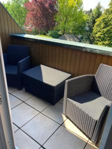 2 Stühle und ein Tisch auf dem Balkon in der Unterkunft Gästehaus Bargteheide in Bargteheide