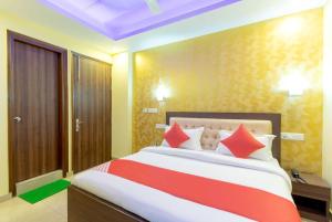 a bedroom with a large bed with red and orange pillows at OYO Flagship Hotel R S Plaza in New Delhi