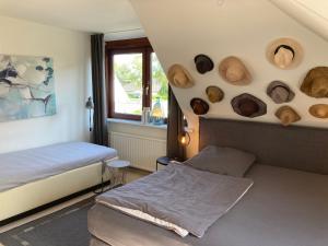 1 Schlafzimmer mit 2 Betten und Hüten an der Wand in der Unterkunft Gästehaus Bargteheide in Bargteheide