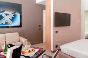 a living room with a couch and a table with a plate of food at Ariha Hotel Cosenza in Cosenza
