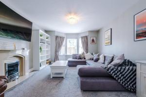 a living room with two couches and a fireplace at 5 bed Luxury Retreat with Spacious Living Spaces in Christleton