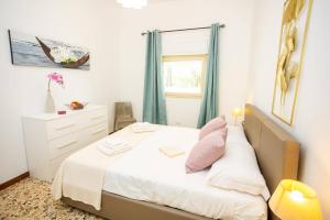 a bedroom with a bed with pink pillows and a window at Villa Ambra by Villa Plus in San Vito dei Normanni +20 photos