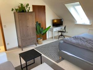 Schlafzimmer mit einem Bett und einem Schreibtisch mit einem TV in der Unterkunft Gästehaus Bargteheide in Bargteheide