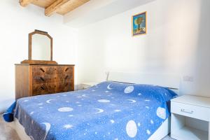 1 dormitorio con cama azul y tocador de madera en Le Matane, en Vittorio Veneto
