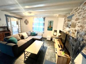 un salon avec un canapé et une table dans l'établissement PENTY DU BELOU, cozy, en pleine campagne, 1 à 6 personnes, à Mellac