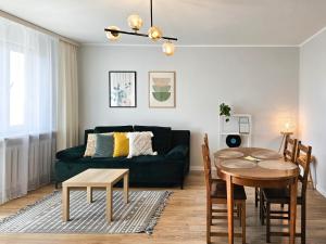 salon z zieloną kanapą i stołem w obiekcie visit baltic - Green Apartment - Chrobrego 02 w Świnoujściu
