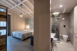 Santa Maria di LicodiaにあるCorten Hotelのベッドルーム1室(ベッド1台、シャワー、バスルーム付)