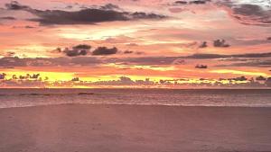 einen Sonnenuntergang am Strand mit dem Meer in der Unterkunft Sea Crest Beach Villa in Ambalangoda