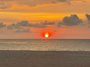 einen Sonnenuntergang am Strand mit Sonnenuntergang in der Unterkunft Sea Crest Beach Villa in Ambalangoda