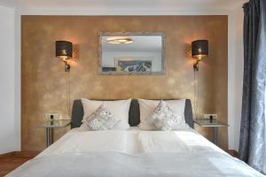 ein Schlafzimmer mit einem weißen Bett mit zwei Lampen in der Unterkunft Ferienwohnung Herzstück im Haus Schlossblick in Füssen
